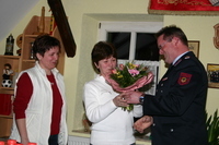 Hubert Steinwachs überreicht den Feuerwehrfrauen einen Blumenstrauß