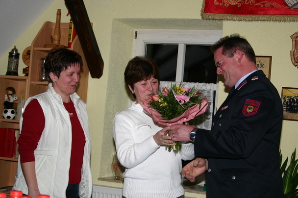 Hubert Steinwachs überreicht den Feuerwehrfrauen einen Blumenstrauß