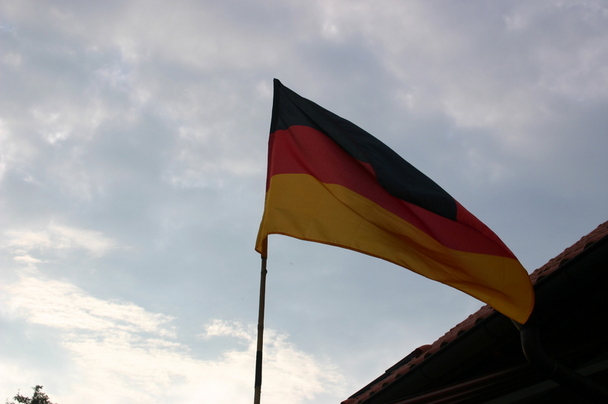 Die Deutschlandfahne weht vor dem idyllischen Abendhimmel